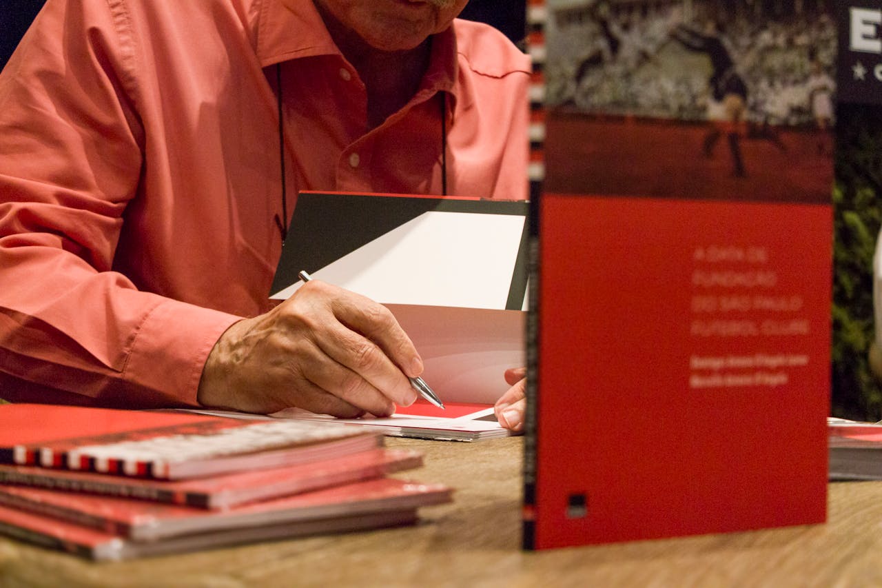 Author autographing books during literary signing session